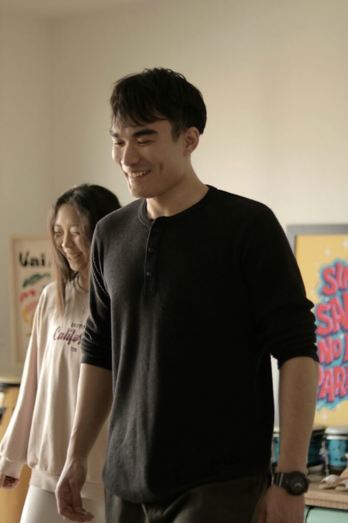 A student smiles while learning a step with a partner