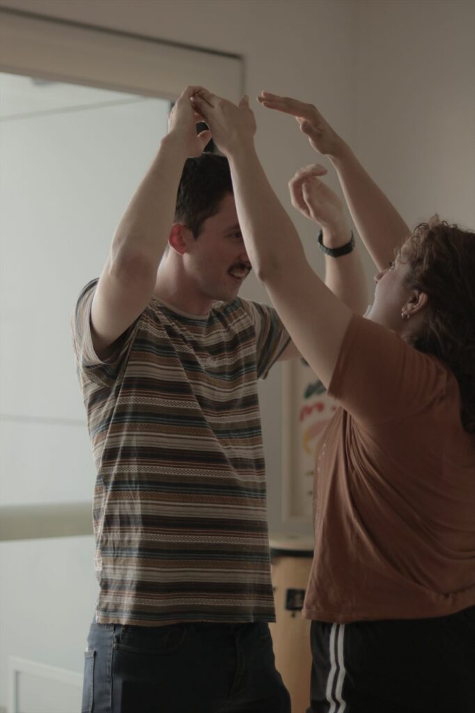 A couple practising a turn with raised arms