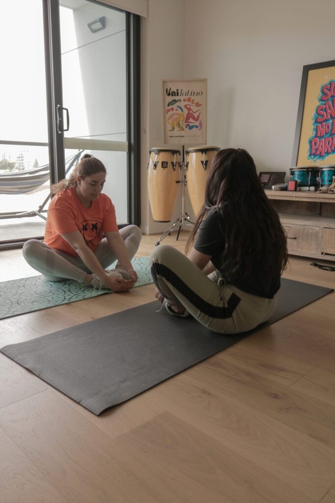 Two students stretching on mats