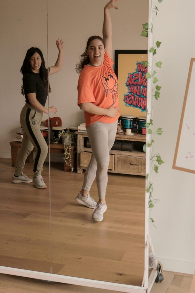 Two dancers mid-move with one arm raised
