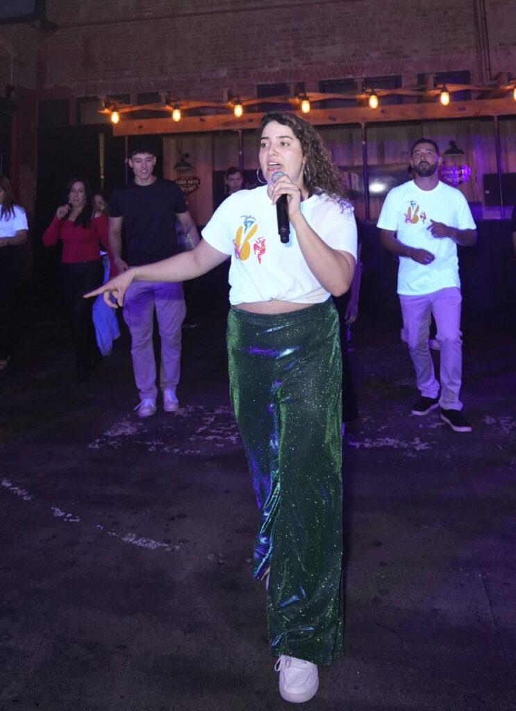 Vanessa leading a group through a dance routine with a microphone